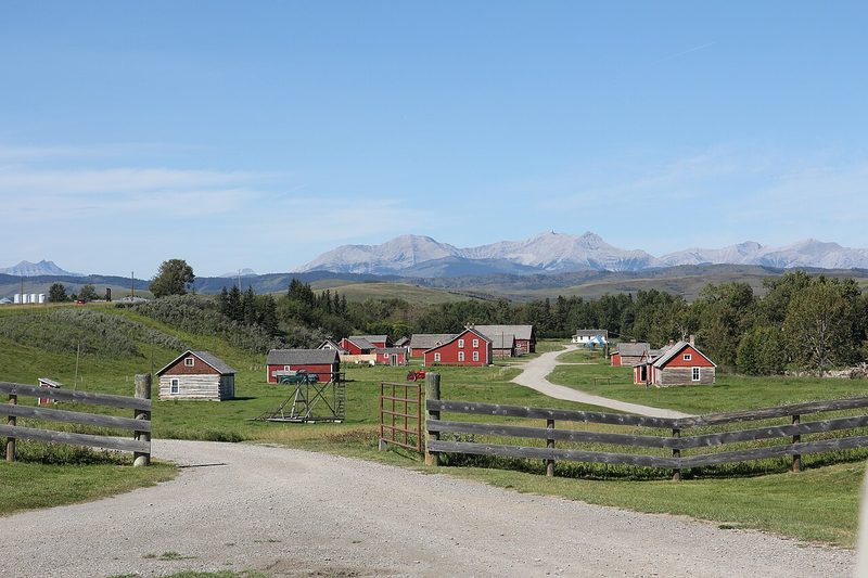 Panorama of Bar U Ranch buildings and road below the Rocky Mountains