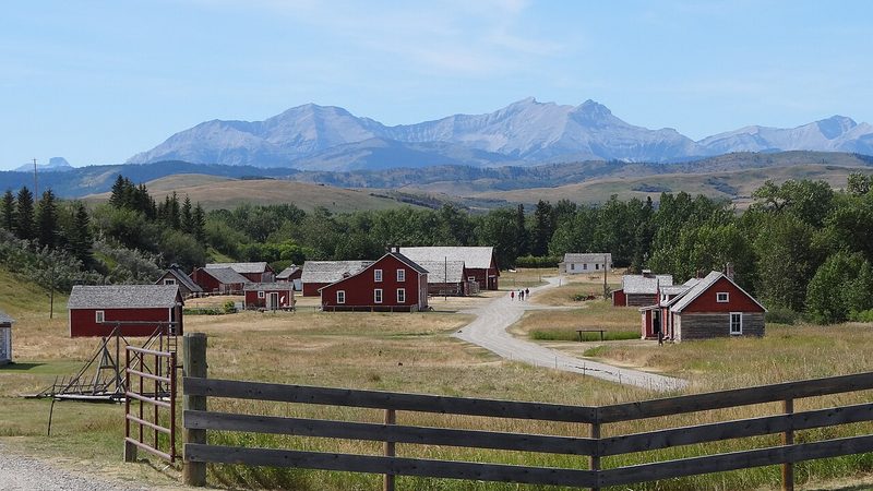 Bar U Ranch buildings and fences with mountains behind, seen from the interpretive centre