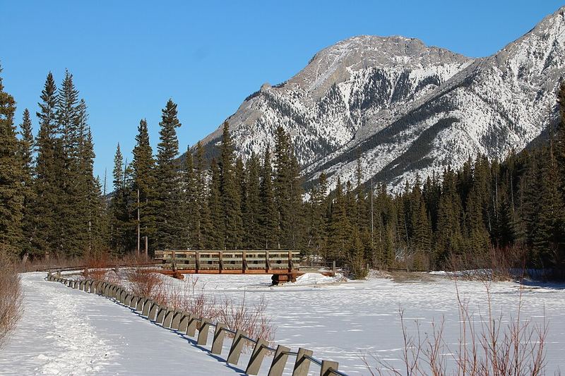 Snowy path and footbridge at Mount Lorette Ponds below Mount Lorette