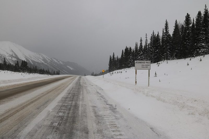Snowy Highway 40 at Highwood Pass with evergreen forest