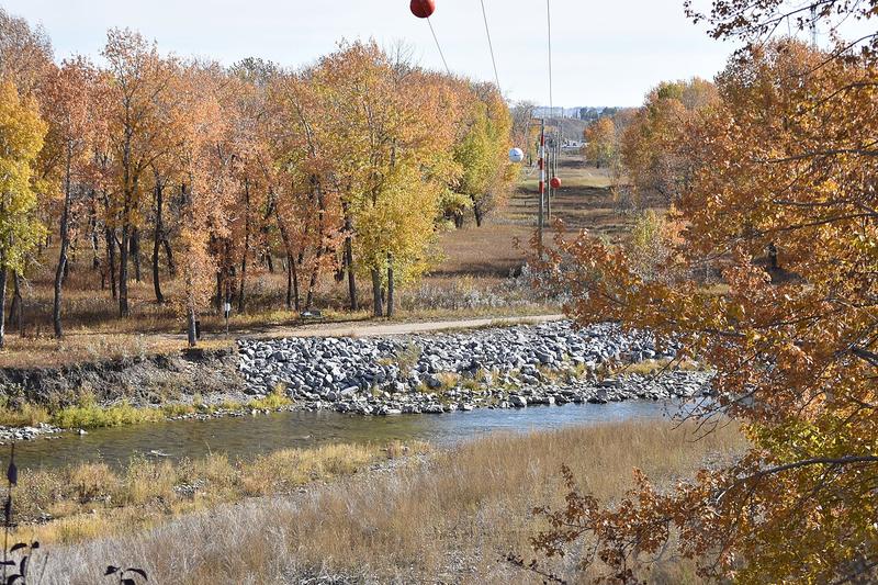 The Sheep River flowing through Okotoks among autumn trees