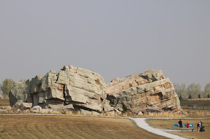 The huge Okotoks Erratic (Big Rock) boulder on the prairie with a path leading to it