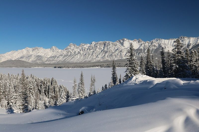 Snowy shore of Lower Kananaskis Lake with mountains in Peter Lougheed Provincial Park