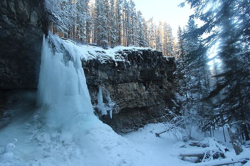 Icy Troll Falls in a snowy rock bowl surrounded by forest